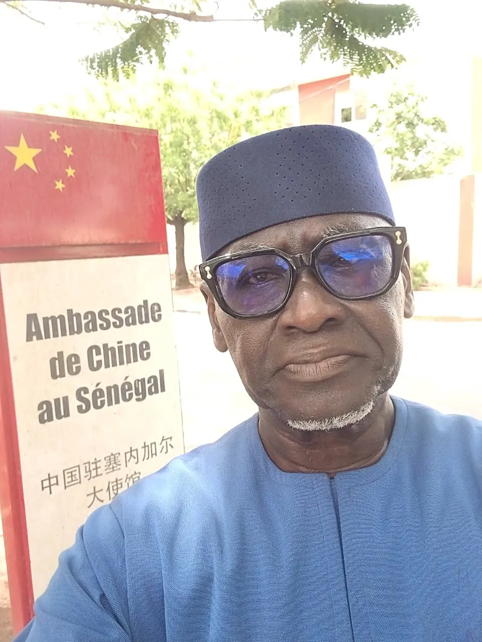 Le coordonnateur du collectif devant le panneau de l'Ambassade de Chine au Sénégal, à Dakar, le jour du dépôt du courrier.